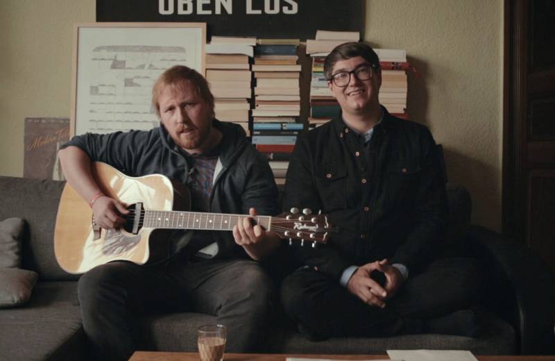 Julius Fischer und Christian Meyer singend auf einem Sofa